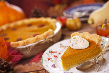 Homemade pumpkin pie on a rustic table with autumn decorations