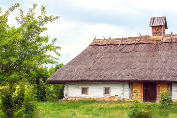 Fototapeta na wymiar Ukrainian hut thatched sloping field near