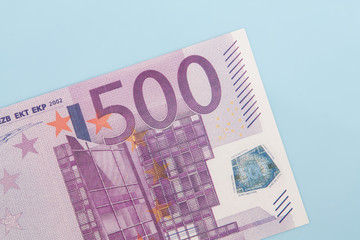 Single 500 euro note on light blue background