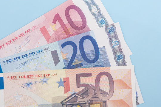 Eighty euro in various notes on light blue background
