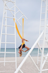 Young woman doing yoga exercise. Yoga with hammock.