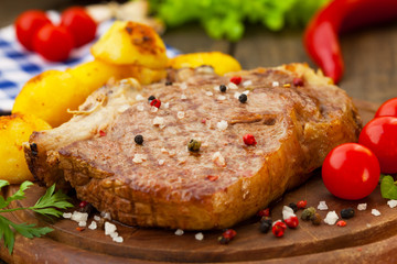 Closeup of roasted beef steak on wooden plate