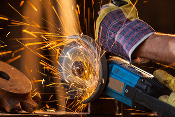 Close-up of worker cutting metal with grinder