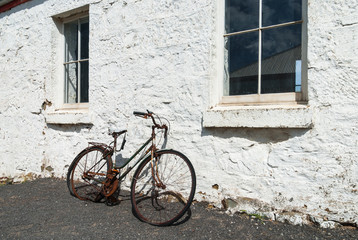 Fototapeta na wymiar Broken old bicycle leaning against old building