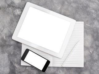 Blank digital tablet, cell phone and diary on a concrete backgro