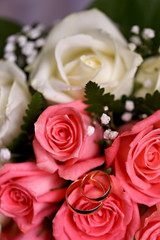 Gold wedding rings on a bouquet of flowers for the bride
