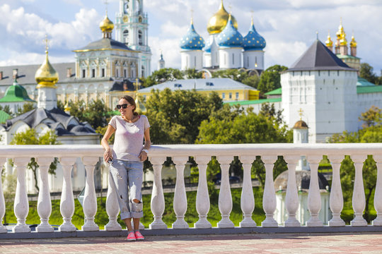 Young Woman in Sunglasses with Trinity Sergius Lavra in Sergiev