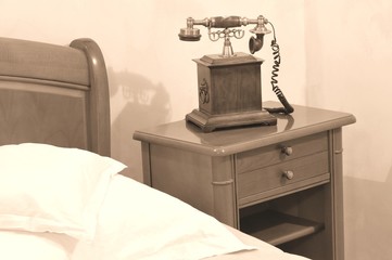 Detail of telephone by the bed in vintage bedroom