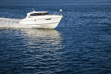 Fototapeta premium White motor boat sailing in calm water