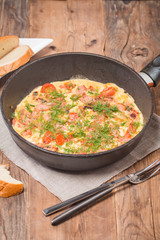 Omelette with sausage, onion, herbs and tomatoes