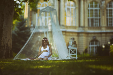 Young pregant women resting in the park.Multiple images was fitted together to became a great field...
