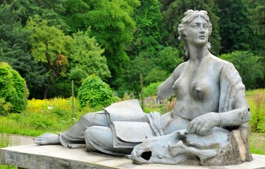 Bronze statue depicting nude woman with book and skull