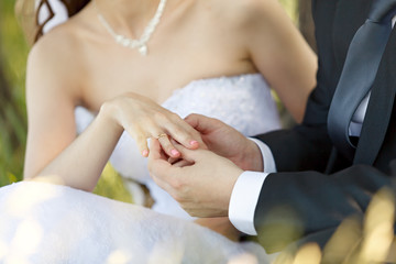 At the wedding, the groom puts the ring on the bride's finger.