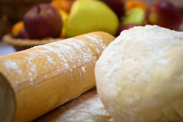 flour close-up, sprinkled on the dough and cooking utensils on a background of apples