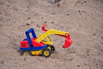 Spielzeugbagger im Sand
