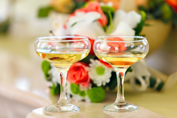Champagne in glasses on a background of a bouquet of flowers 