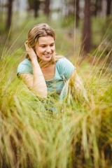 Young pretty hiker sitting in the high grass