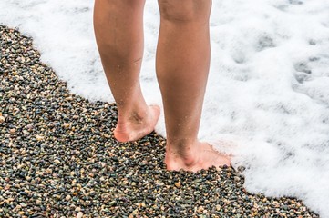 Young girl standing in the water on the sea shore