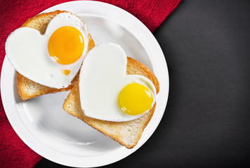Two heart-shaped fried eggs and fried toast