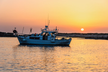 Fototapeta premium Fishing boat lies at sundown 