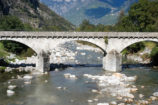 Old stone bridge over river Ticino at Biasca