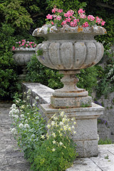 elegant garden vase with pink geranium and columbine flowers on