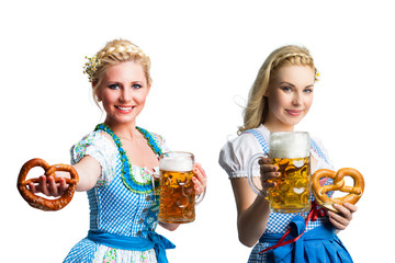 zwei attraktive Frauen im Dirndl mit Bier und Brezel vor freigstelltem Hintergrund