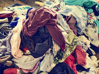 pile of used clothes on sale in a flea market, filtered