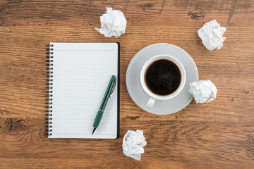 crumple paper, notebook and pen with cup of coffee