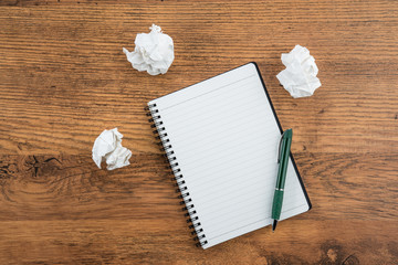 crumple paper and pen with notebook on the desk