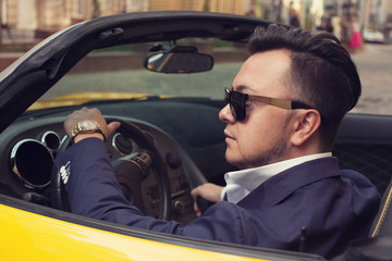 Stylish man sitting in sport car