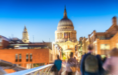 People moving on Millennium Bridge at night - London