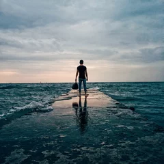 Foto op Plexiglas Man with a bag stands on a pier © steb_nick