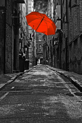 Red umbrella in a dark urban alleyway