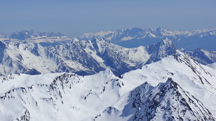 Fototapeta na wymiar many beautiful alpine peaks in winter and white snow
