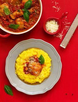 Baked rabbit in tomato sauce and served with risotto. Italian Cuisine.