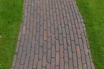 Weg mit Klinkerbelag durch Grünanlage