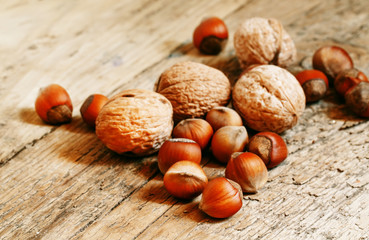 Hazelnuts and walnuts on an old wooden table, selective fokuks