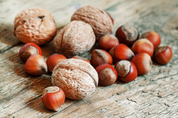 Hazelnuts and walnuts on an old wooden table, selective fokuks