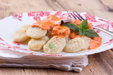 gnocchi with tomato sauce and basil on a tablecloth 