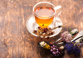 Cup of herbal tea with wild flowers and various herbs