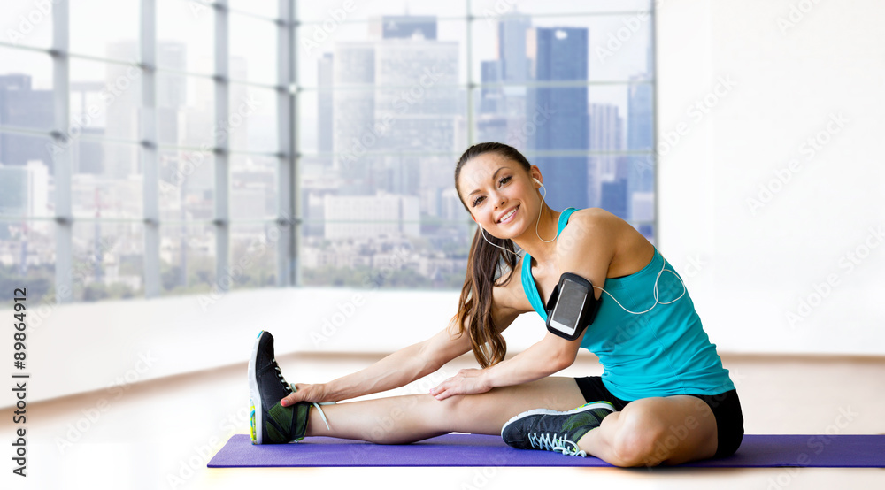 Canvas Prints smiling woman stretching leg on mat over gym