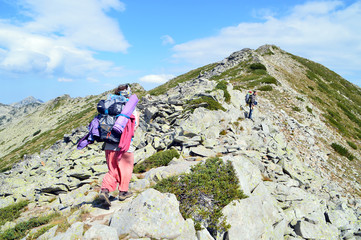 Two Young People Hiking Up On Stony Mountain Ridge