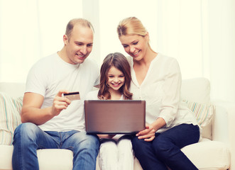 parents and girl with laptop and credit card