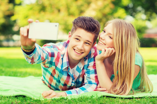 smiling couple making selfie in park