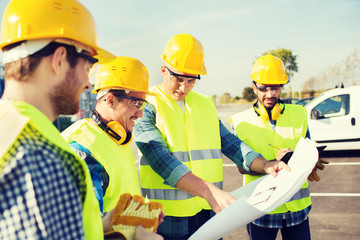 group of builders with tablet pc and blueprint
