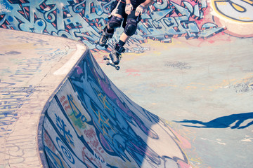 Saut du rollerman dans un skatepark avec graffitis