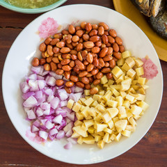 Side dishes eat with Thai style fried mackerel fish serving with fresh salad , rice noodle and spicy dressing sauce.