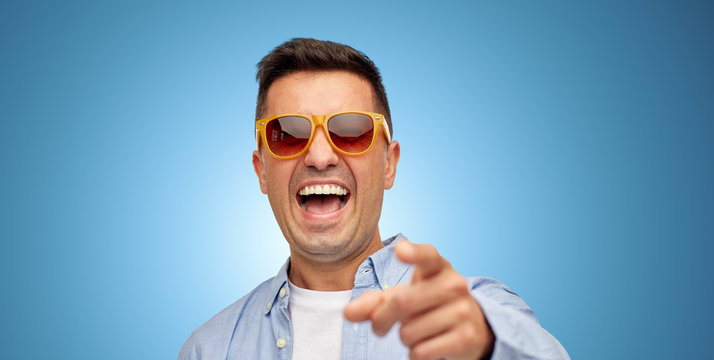 face of laughing man in shirt and sunglasses