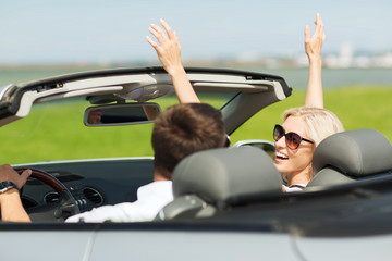 happy man and woman driving in cabriolet car